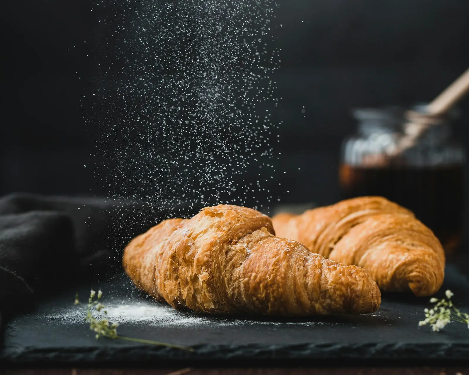 Example creator post: two golden croissants dusted with sugar on a slate board