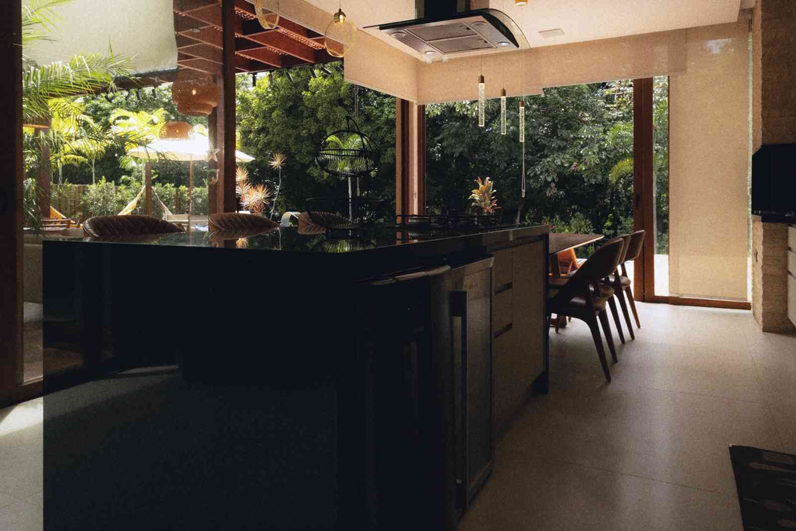 After: the new lower-ground kitchen with dark units and a glazed wall to a planted lightwell