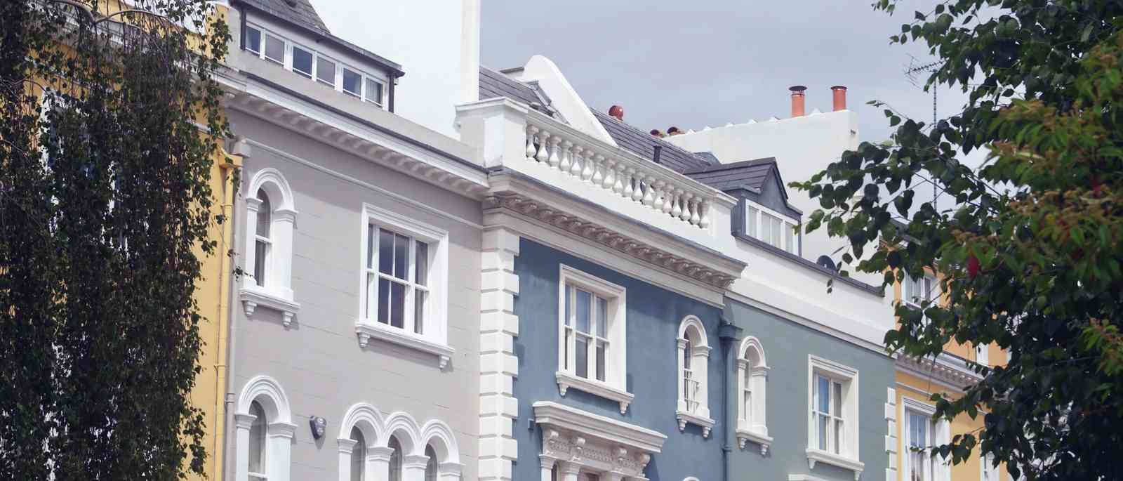 A row of pastel-painted London terraced houses
