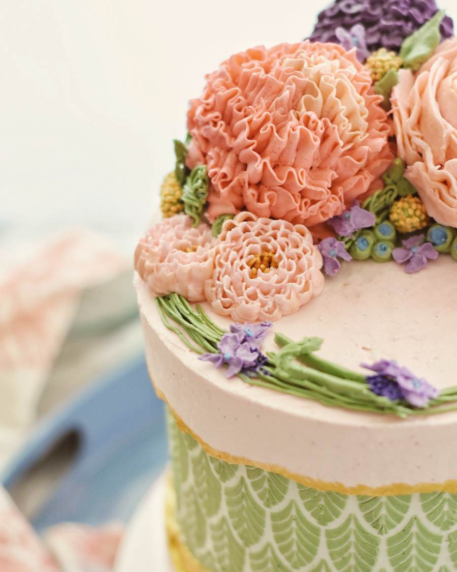 A pink cake topped with piped buttercream peonies