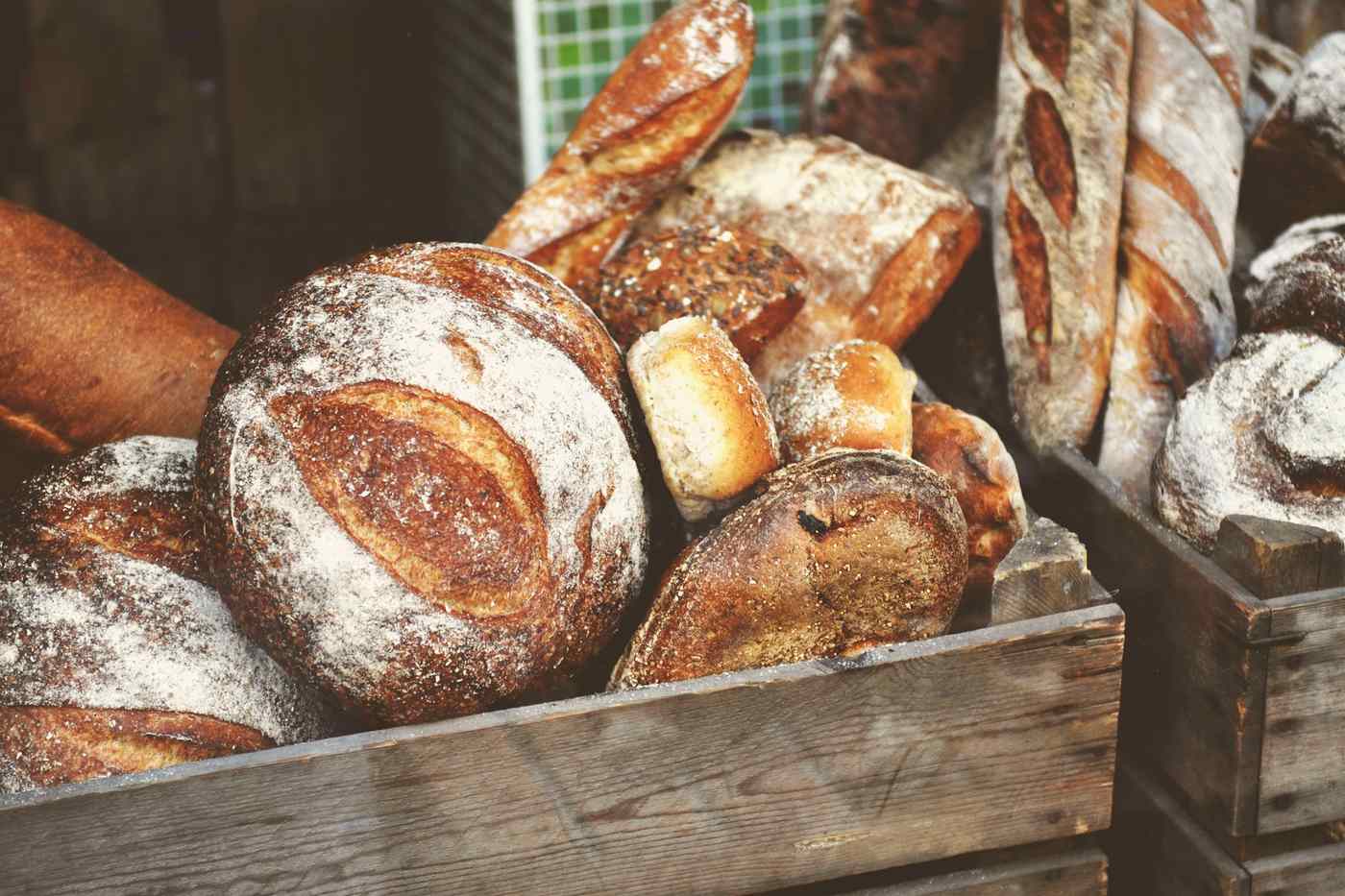 A wooden crate of crusty sourdough loaves ready for delivery