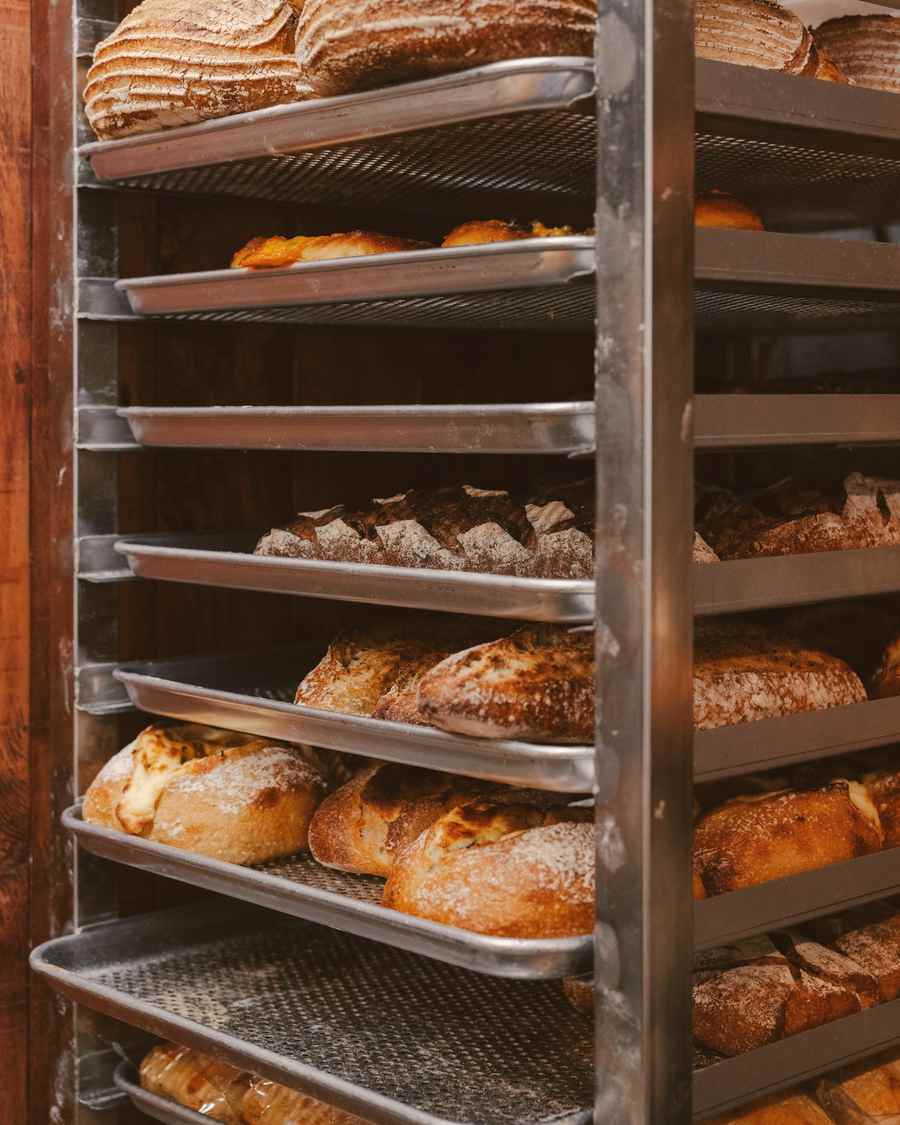 A tall rack of freshly baked loaves cooling in the bakehouse