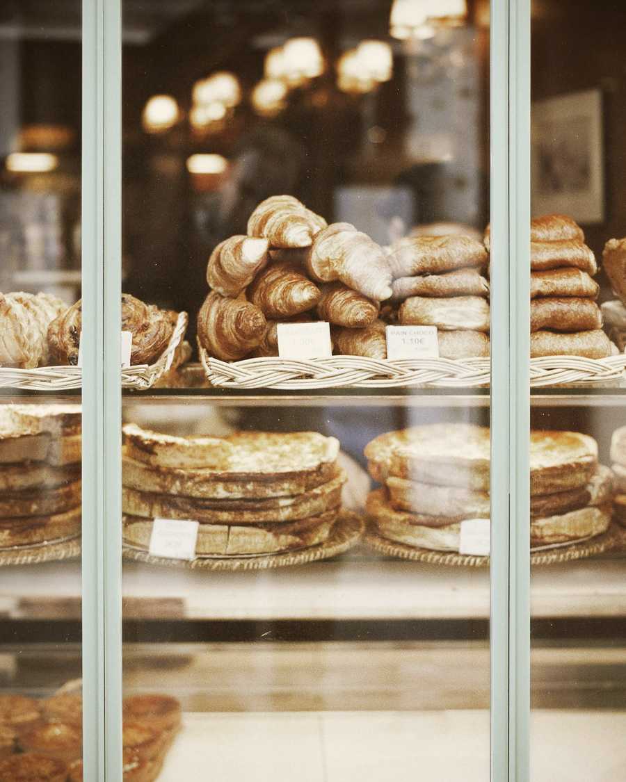 Pastries and loaves stacked in a glass-fronted display