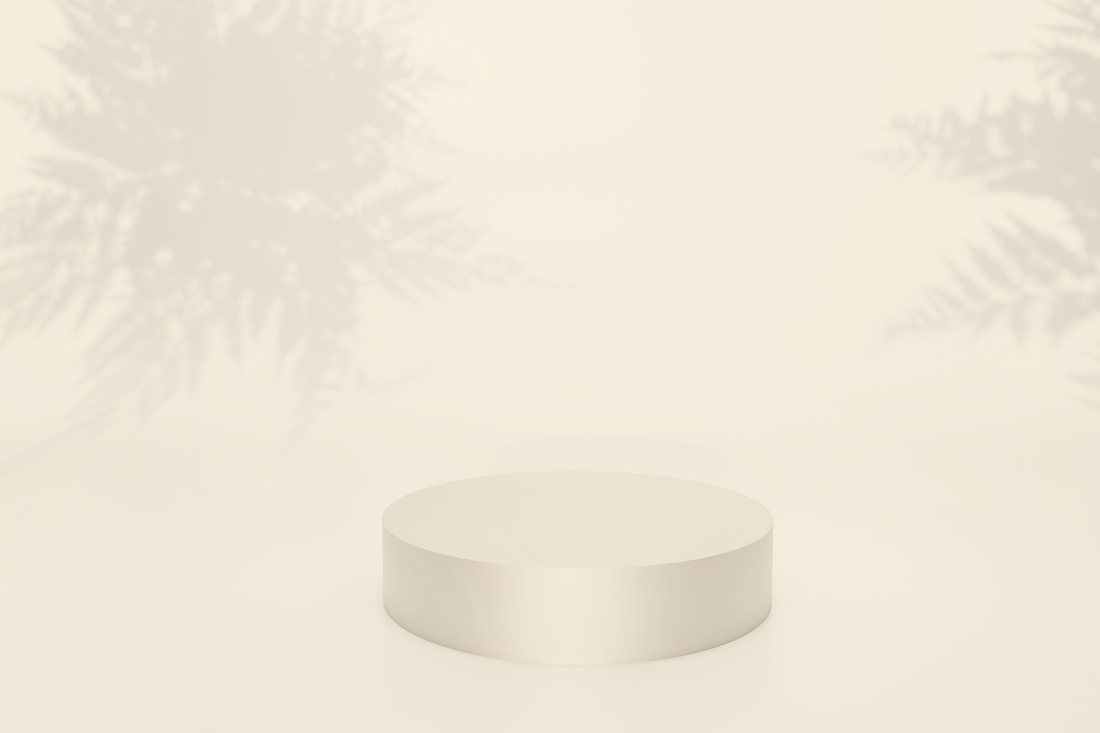 A champagne-coloured plinth on ivory with soft leaf shadows