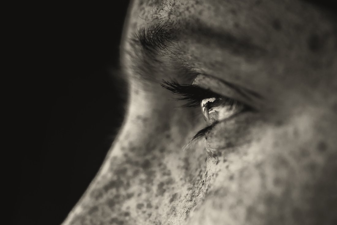 Profile of a face in black and white with long lashes catching the light