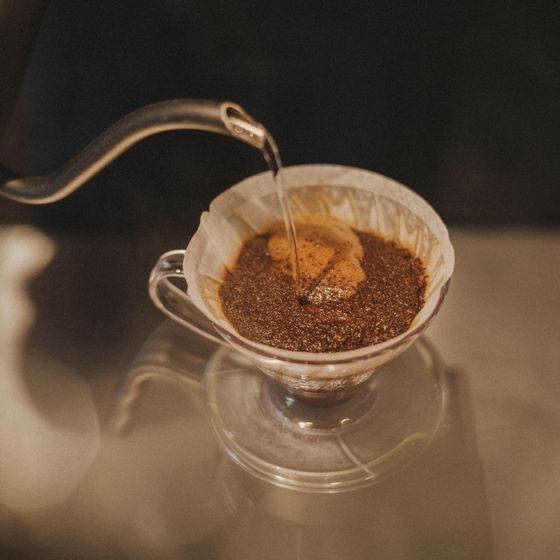 Hot water poured over coffee in a glass dripper