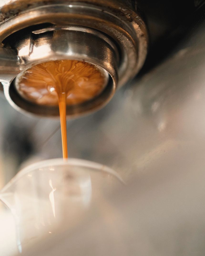 Espresso pouring from a portafilter into a glass