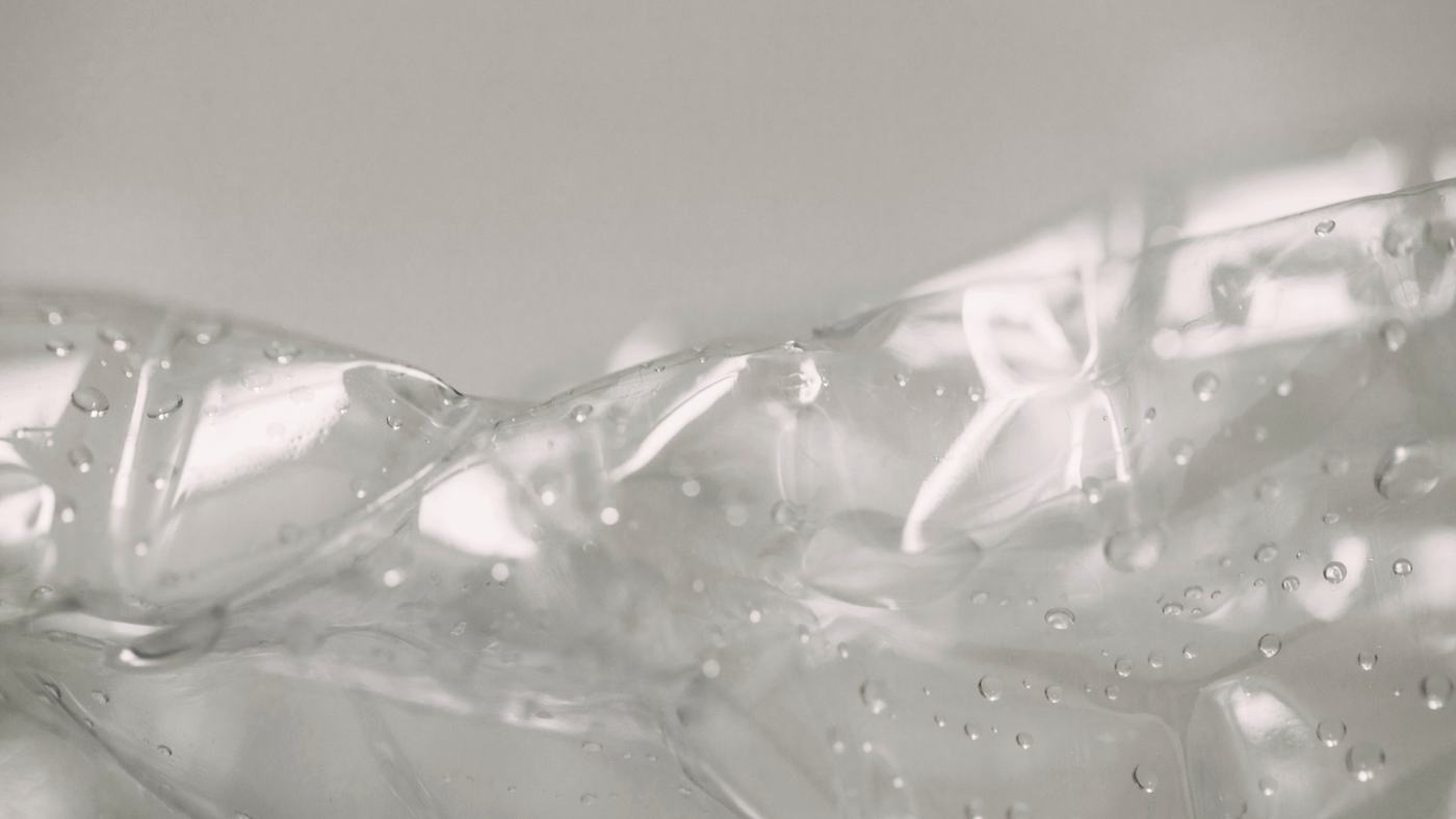 Clear gel spread across a grey surface, in macro