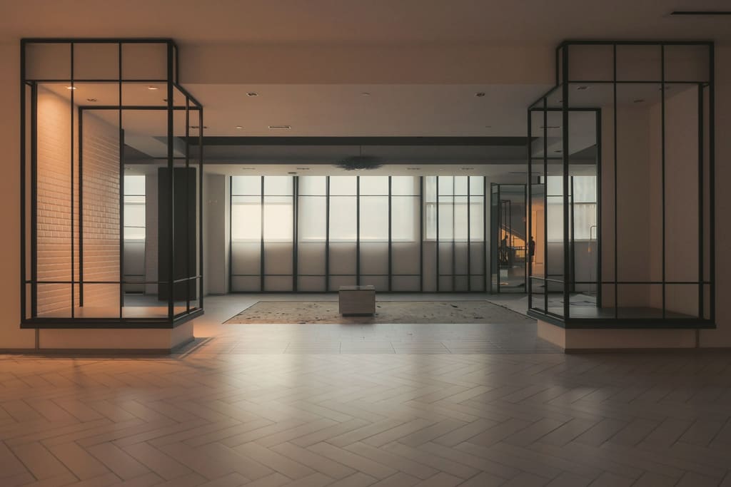 A large empty event floor with warm timber and black steel frames