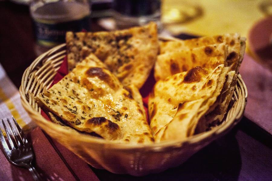 A basket of tandoori naan and paratha