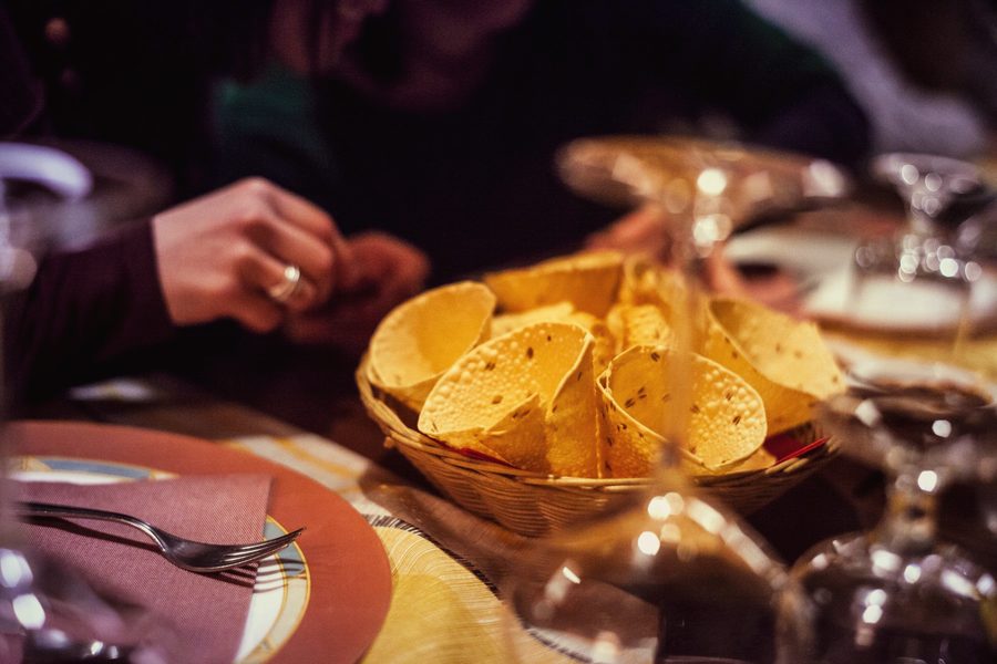 Guests reaching for poppadoms at a candlelit table