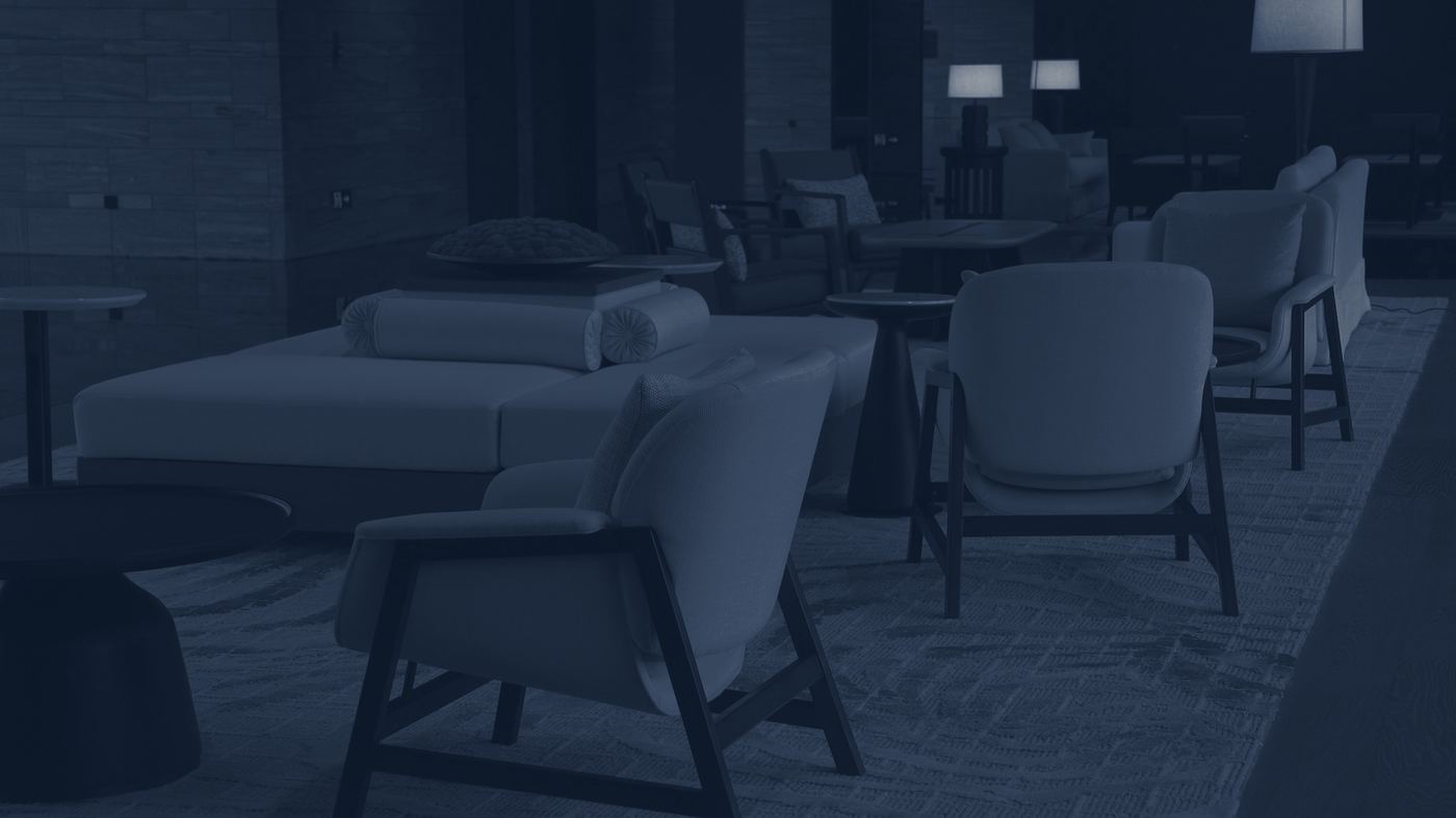 A dim, softly lit sitting area with deep armchairs and table lamps