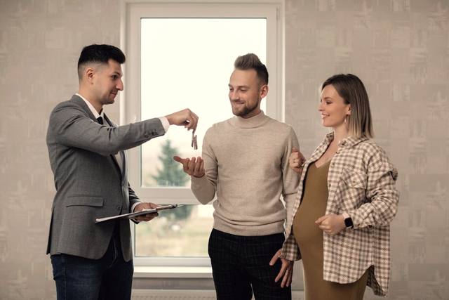 An agent handing a set of keys to a couple in their new home