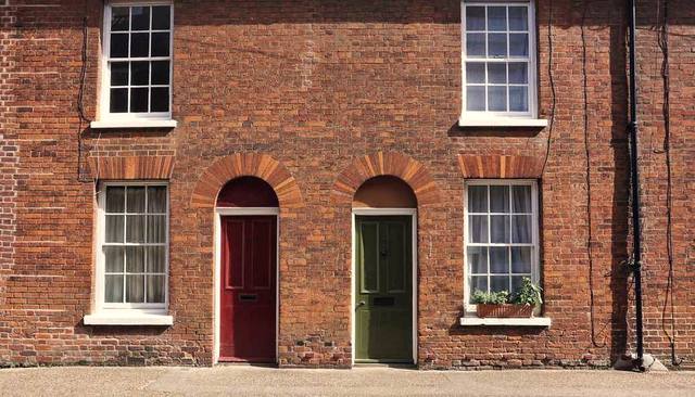 Brick terraced houses with arched doorways on a quiet avenue