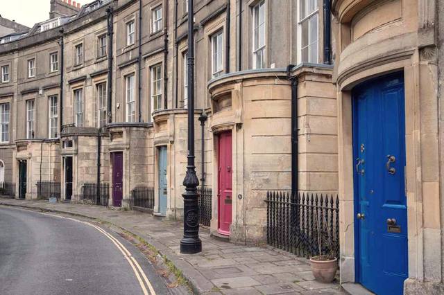 A curved street of period houses with bright front doors