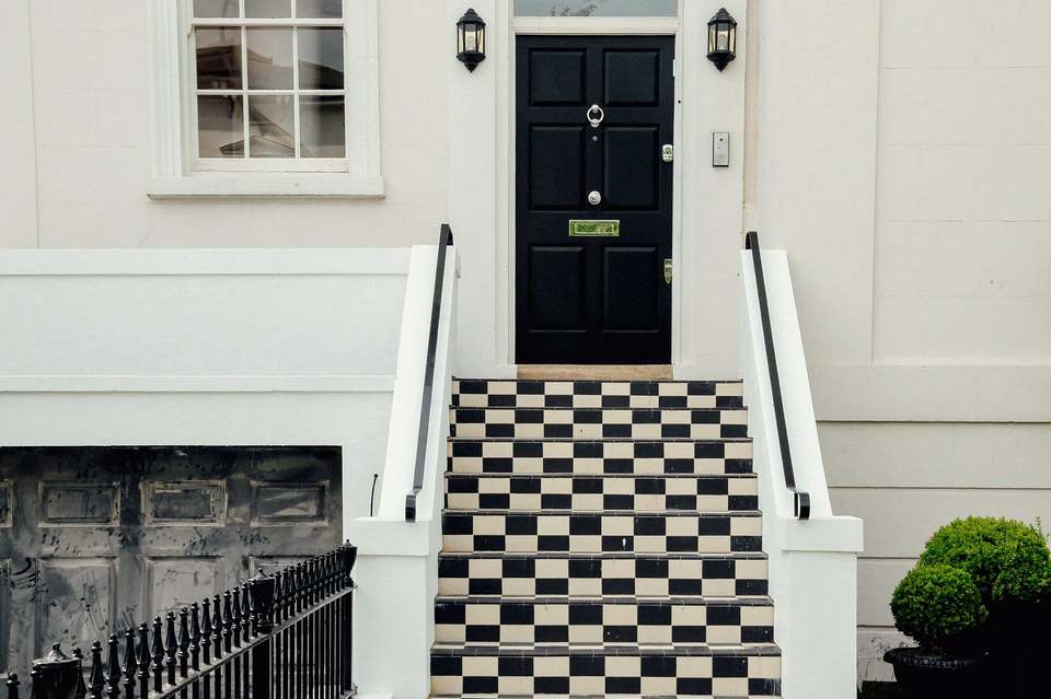 A black lacquered front door above chequered steps