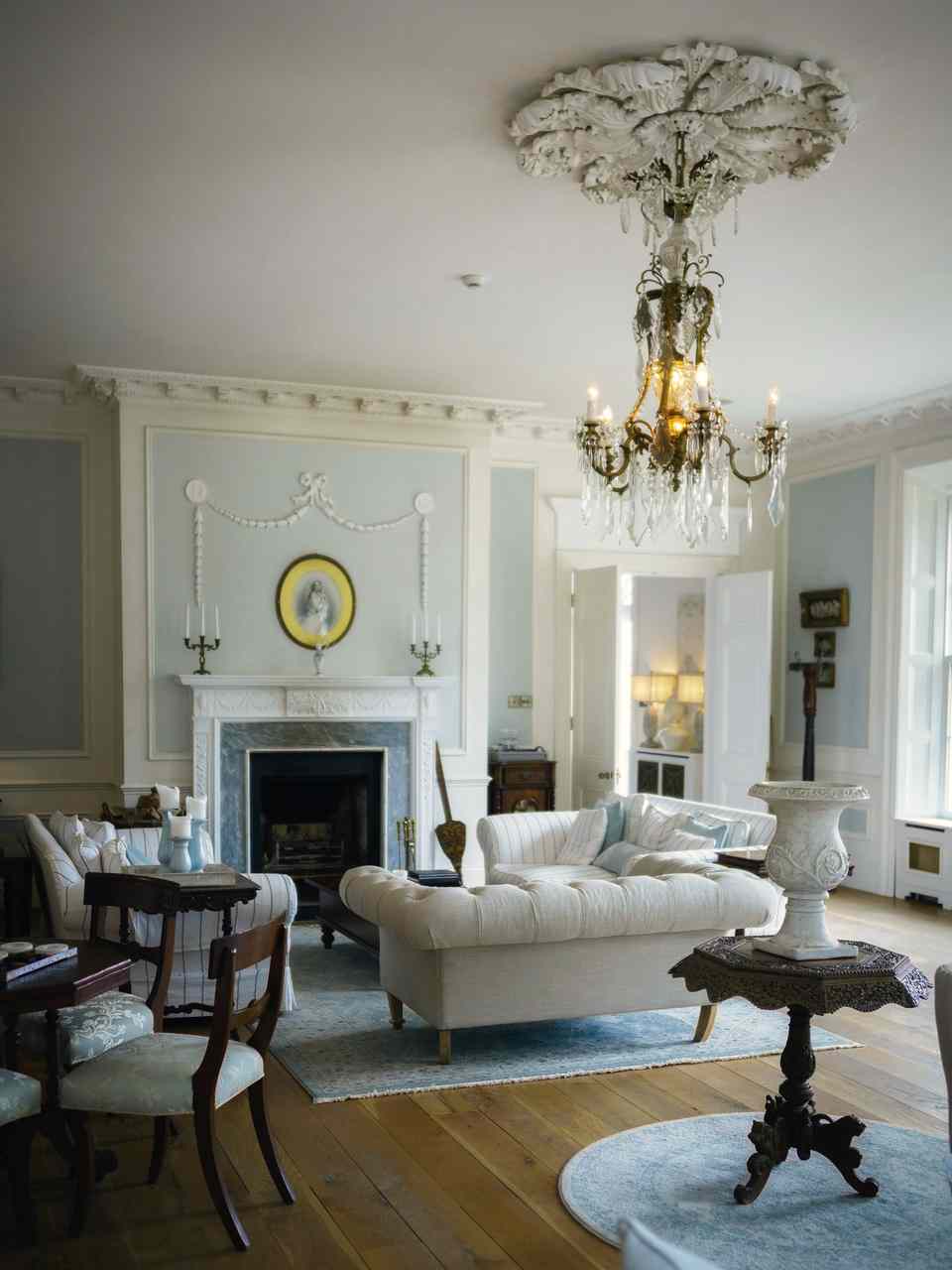 A tall white drawing room with a chandelier