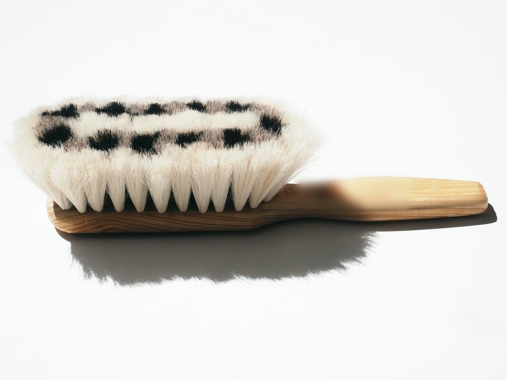 A natural bristle hand brush with a wooden handle