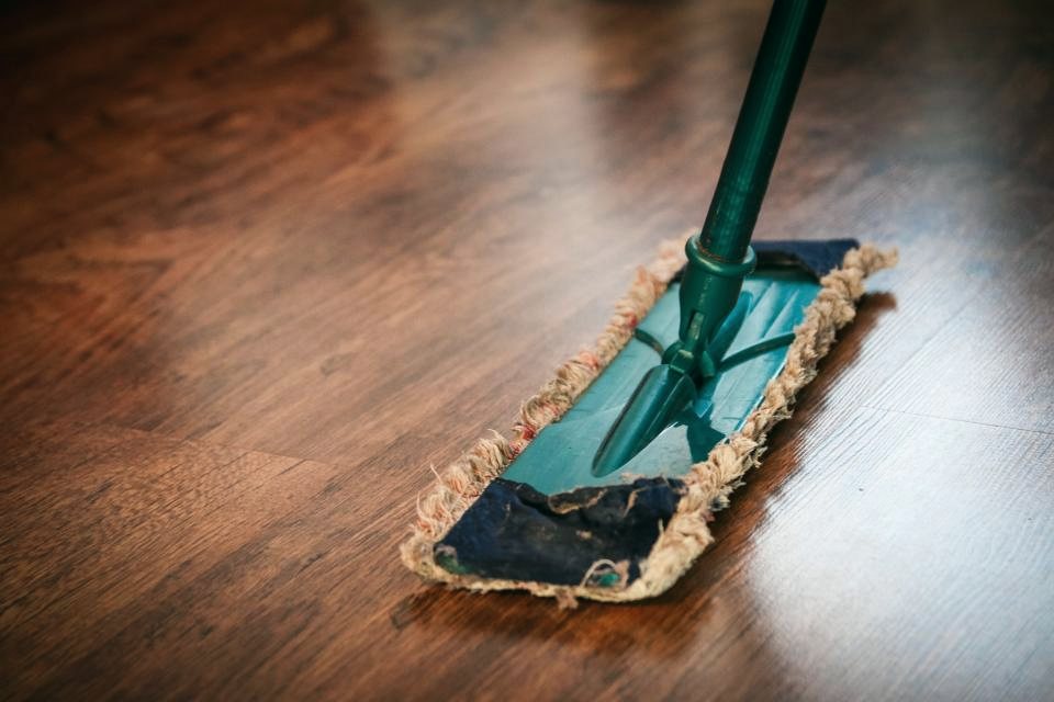 A flat microfibre mop gliding over a polished wooden floor