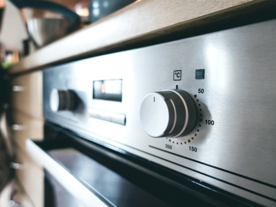 Close-up of a clean stainless steel oven dial