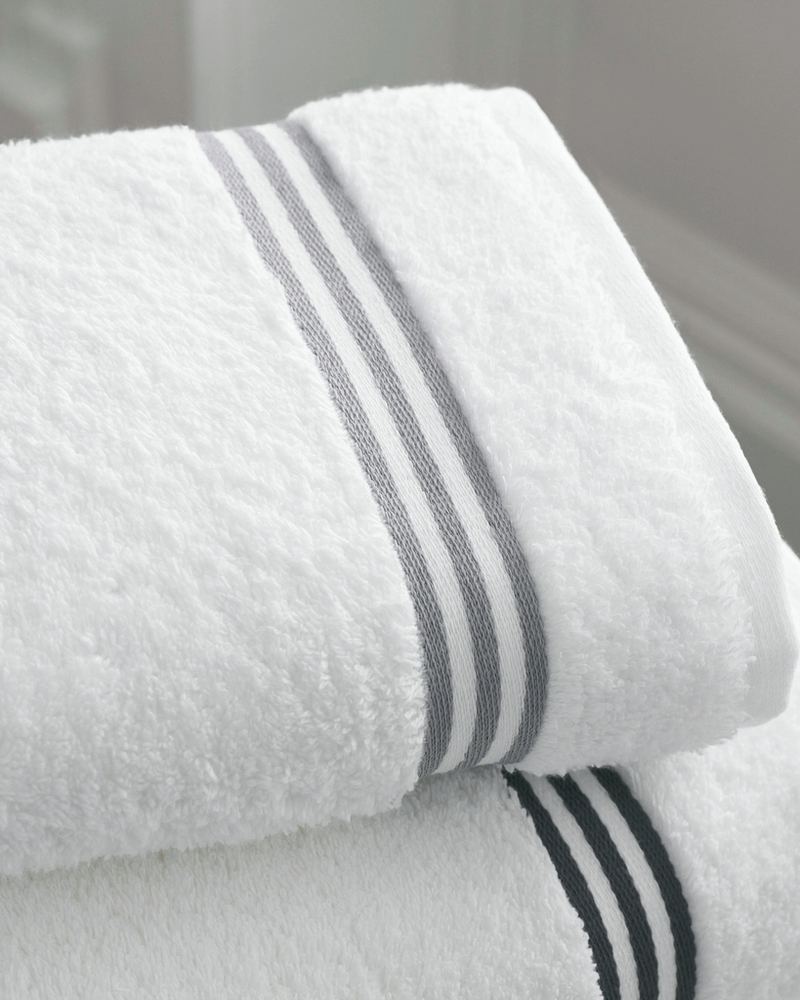 Neatly folded white towels with a grey stripe