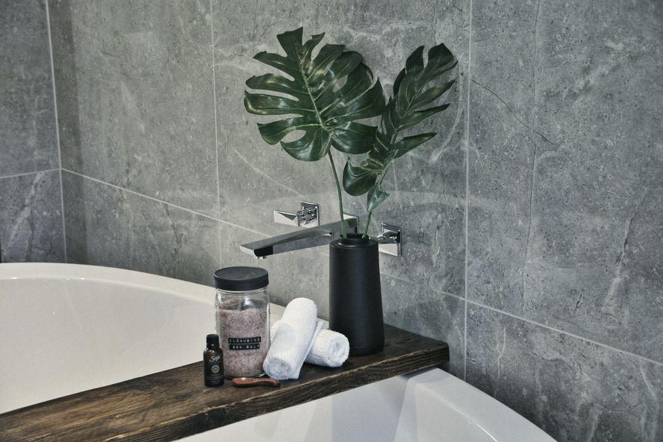A freestanding bath against stone-effect tiles