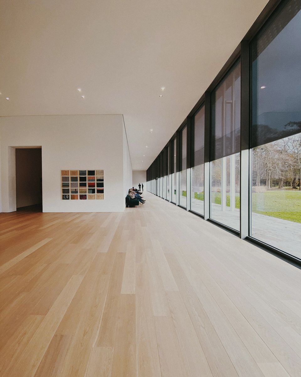 A long hallway with timber floors and full-height glazing