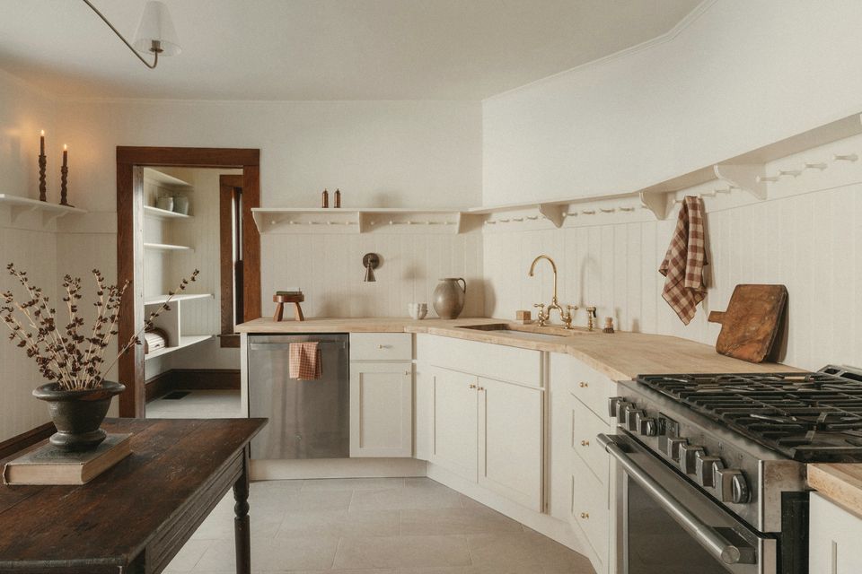 A painted kitchen with open shelves and a range cooker in soft daylight