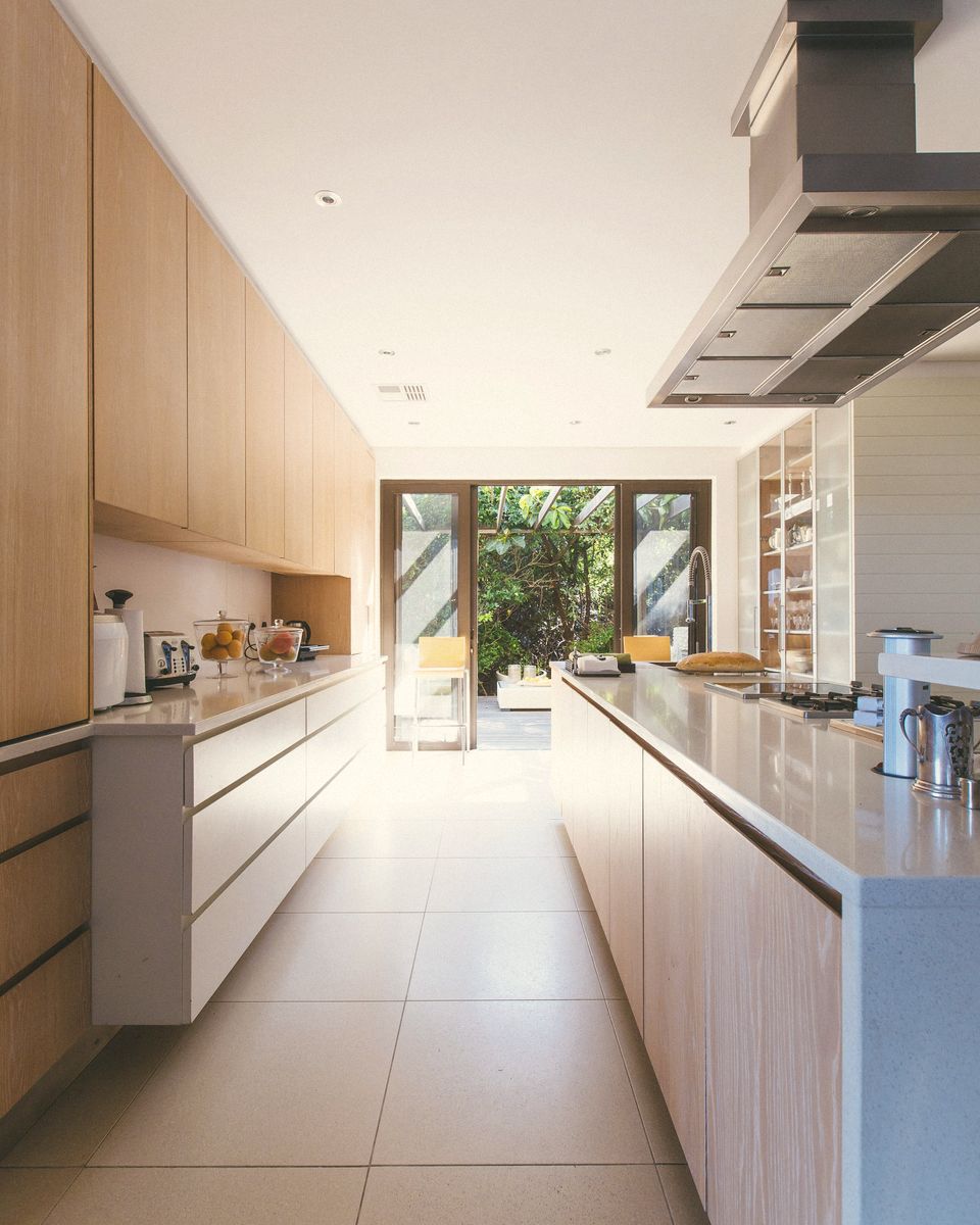 A long kitchen with timber units leading to garden doors