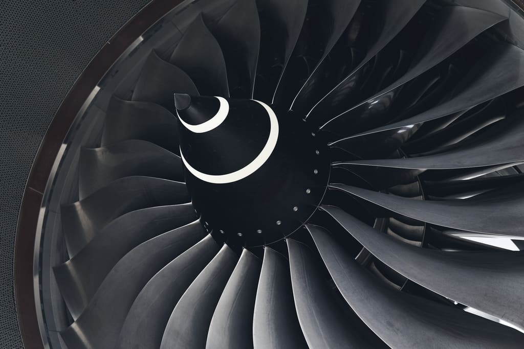Close view of a jet engine fan, blades curving into the hub
