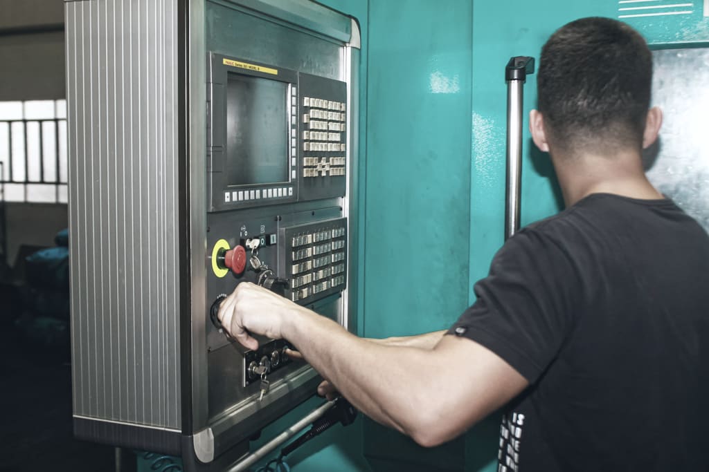 A machinist at the control panel of a CNC machining centre