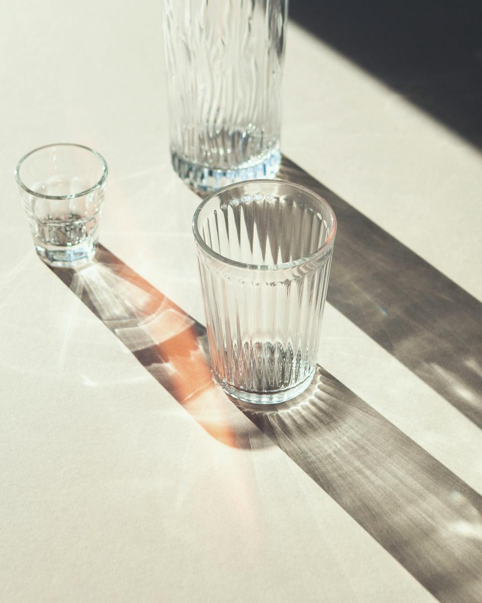 Ribbed glass tumblers casting long shadows in low sun