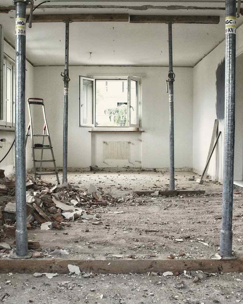 A house stripped back to brick and joists with acrow props holding the ceiling during renovation