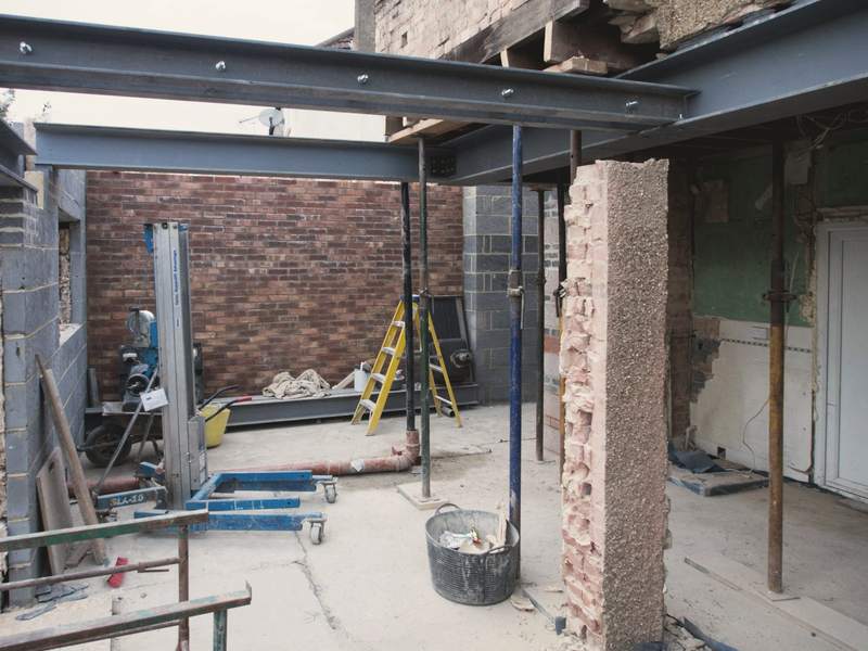 Steel beams installed across the opened back of the house