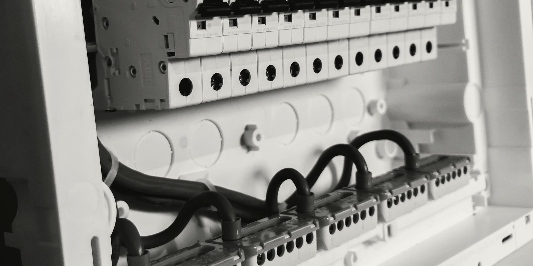 Close-up of a new consumer unit: white breakers and neatly dressed cables