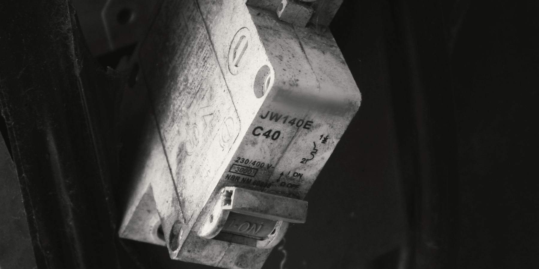 An old fused switch on a dark wall, lit from one side